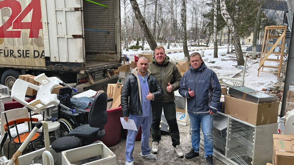 Chirurg Konstantyn Pashchenko nimmt von Spediteur Michael Bockelkamp und seinem Mitfahrer Thomas Ellinger (v.l.) die Spende für die Charkiwer Kinderklinik entgegen.