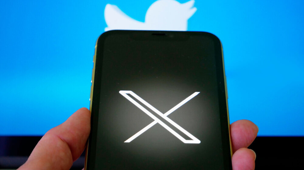 Handy mit neuem Logo X für Twitter auf blauem Hintergrund mit weißem Vogel. Handy mit neuem Logo X für Twitter auf blauem Hintergrund mit weißem Vogel.