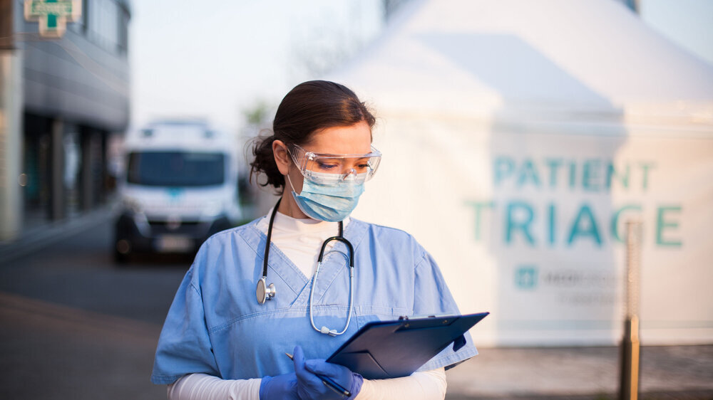 Young caucasian female doctor in front of emergency medical services clinic Triage Notfallambulanz