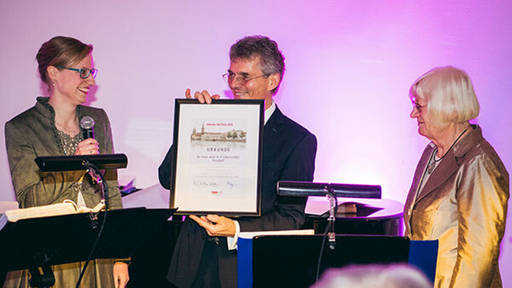 Wiebke Volkmann überreicht Dr. Heinz-Peter Olbertz die Urkunde zum Lübecker hoT-Preis 2018.