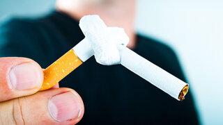 Mann hält gekotete Zigarette