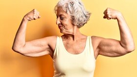 Senior grauhaarige Frau trägt legere Kleidung zeigt Arme Muskeln lächelnd stolz. Fitness-Konzept.