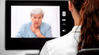 Kranke Patientin in der virtuellen Sprechstunde am Monitor, Fernbehandlung und Telematik im Gesundheitswesen