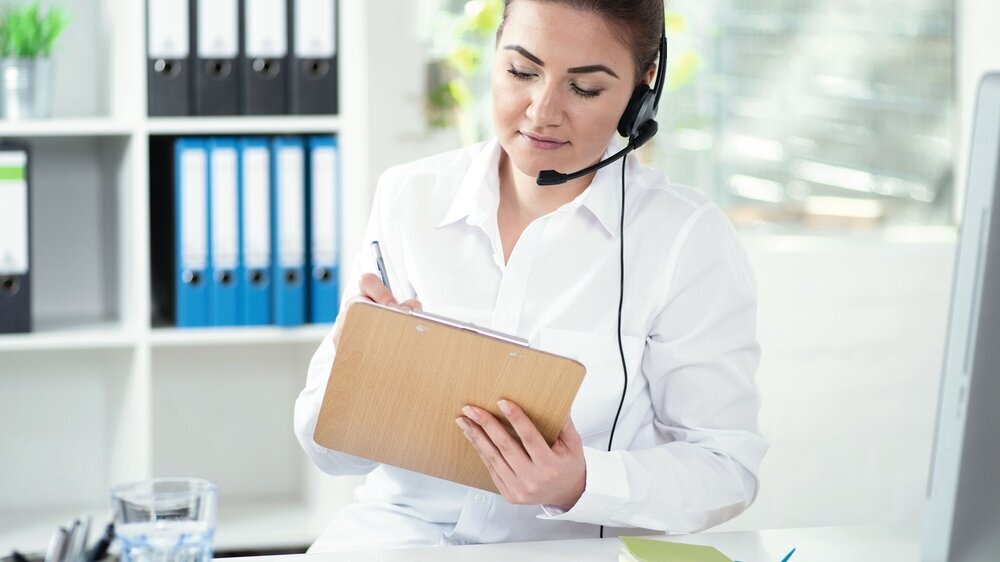 Frau mit Headset sympathisch lächelnd im Arztbüro. Frau mit Headset sympathisch lächelnd im Arztbüro.