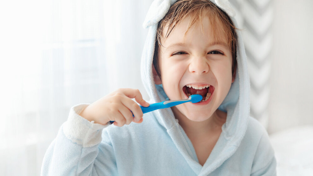 Junge putzt sich die Zähne am Morgen.