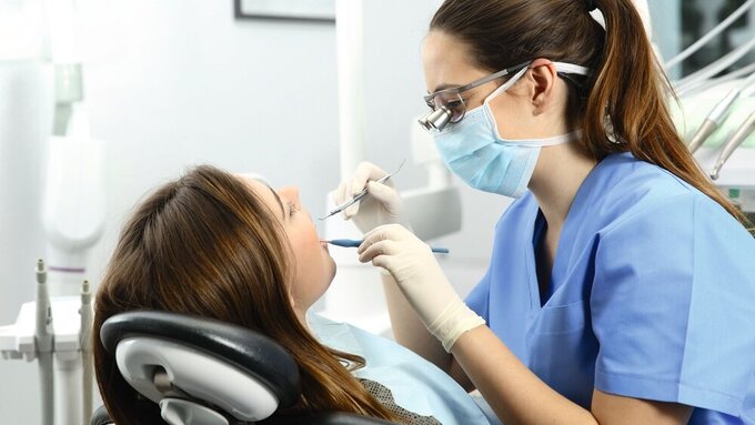 Dentist examining a patient teeth ZFA