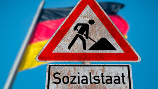 Flagge von Deutschland und Schild Baustelle Sozialstaat