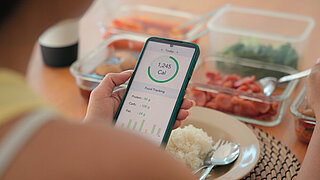 Young adult black asia people active gen z using AI phone record data daily meal tracker clean food diet app control. Asian Smart living care happy life goal routine plan lunch time home dining table.