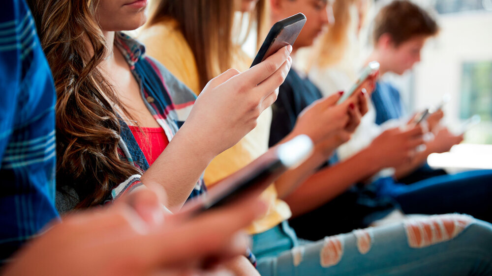 Nahaufnahme einer Reihe von Schüler mit Smartphones. Nahaufnahme einer Reihe von Schüler mit Smartphones.