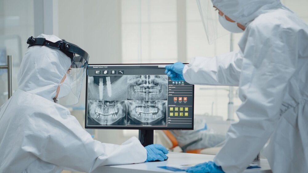 Team of stomatologists analyzing dental x ray scan Implantate auf Röntgenscan