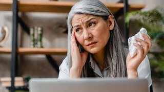 Sick beautiful caucasian middle-aged woman suffering from allergy or flu in office