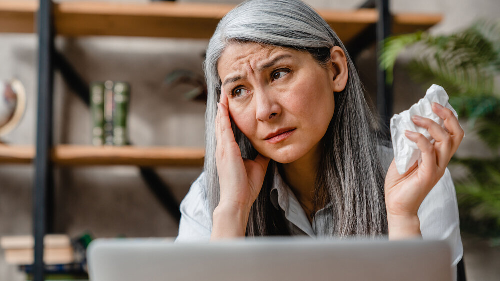 Sick beautiful caucasian middle-aged woman suffering from allergy or flu in office Sick beautiful caucasian middle-aged woman suffering from allergy or flu in office