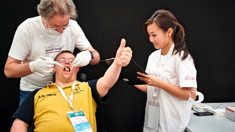 Bei Special Smiles gescreent: Tischtennisspieler Kai Sausemuth bei der Zahnuntersuchung mit dem Arzt und Zahnarzt Dr. Peter Minderjahn und der ZFA Anhthu Huynh. |
