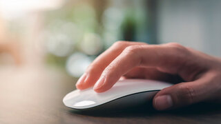 Close up of hand using on white mouse and clicking on office table.