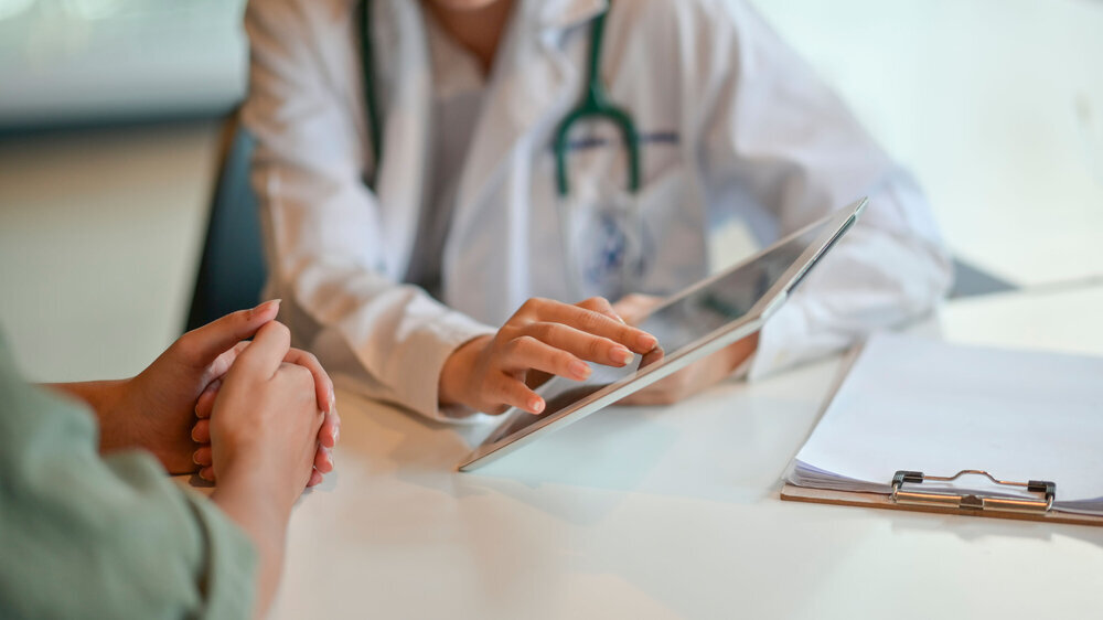 Shot of a doctor showing a patient some information on a digital tablet Krankenhausarzt zeigt Patient Daten auf Tablet