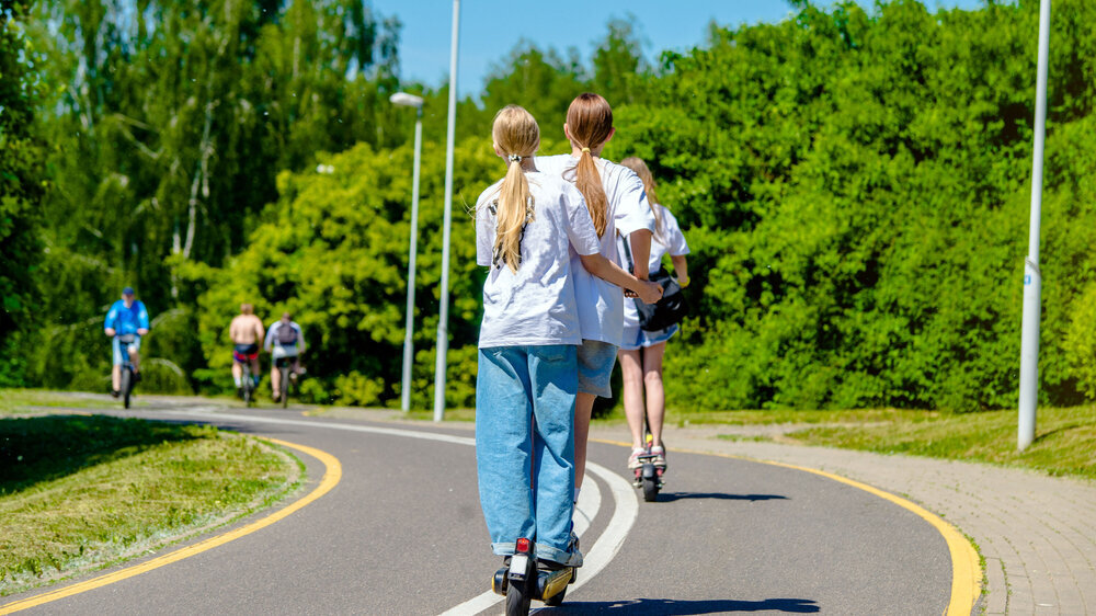 Kinder auf einem E-Scooter Kinder auf einem E-Scooter