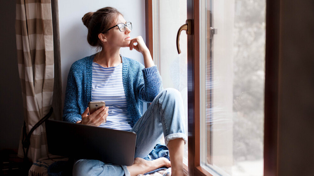 Corona-Isolationspflicht. Junge Frau mit Laptop, Telefon im Home Office. Corona-Isolationspflicht. Junge Frau mit Laptop, Telefon im Home Office.