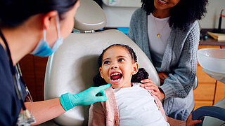 Child, mouth and consultation with dentist in office for dental checkup, show cavity and extraction. Mother, kid and paediatric hygienist for oral health, teeth whitening and inspection for cleaning.