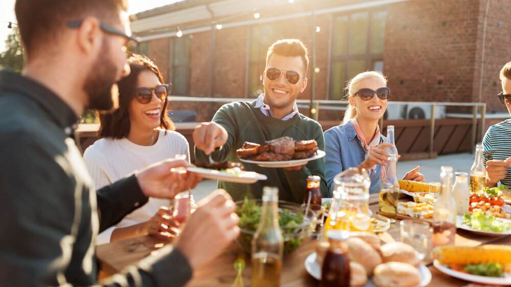 Glückliche Freunde beim Grillen auf der Dachterrasse Glückliche Freunde beim Grillen auf der Dachterrasse