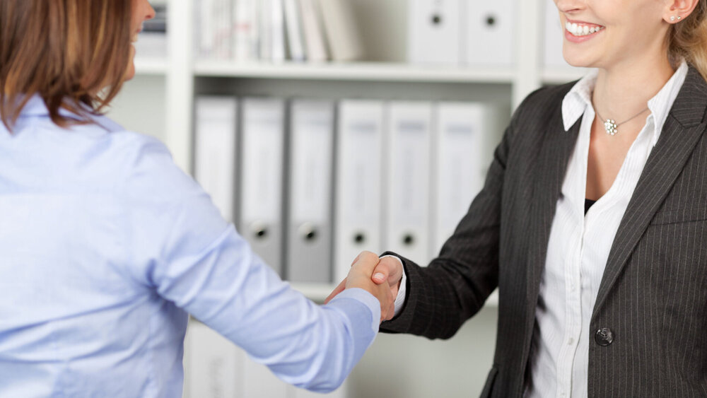 zwei frauen geben sich die hand