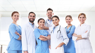 Junges Team von Ärzten steht zusammen in der Ausbildung.