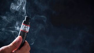 E-Zigarette inklusive nachfüllbarem Tank für E-Liquids vor schwarzem Hintergrund.