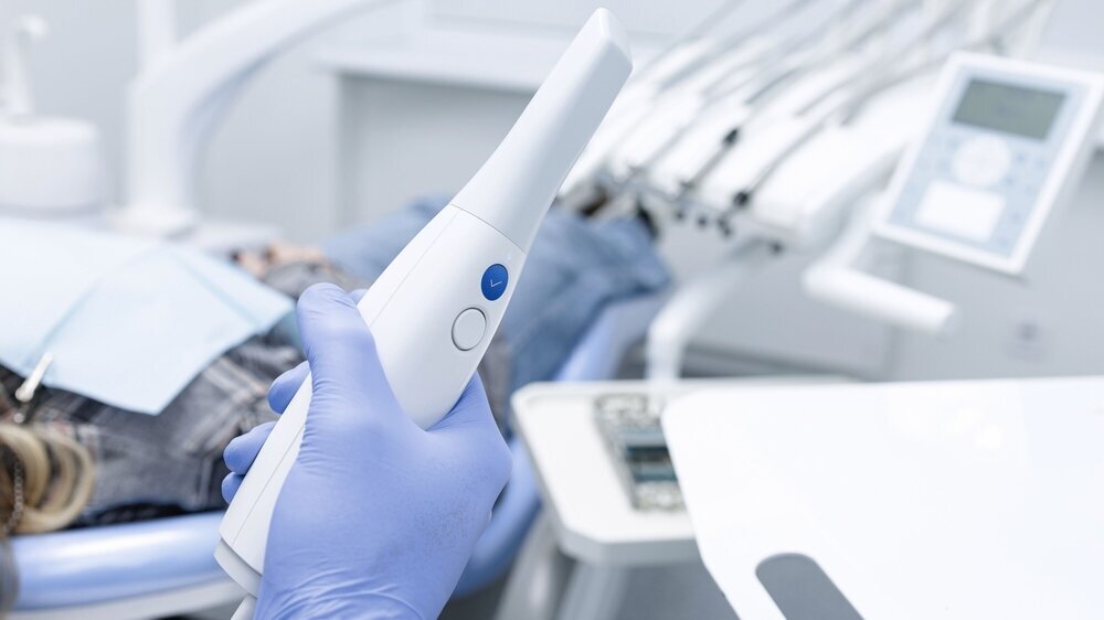 Intraoral 3D Scanner for Digital Impression and CAD CAM Workflow in Dental Clinic Gloved hand holds intraoral 3D scanner for digital impression and CAD CAM workflow in modern dental office
