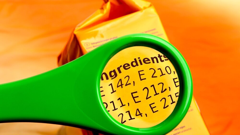 Concept of reading ingredients list on food package with magnifying glass. Magnifying glass on food additives label. Lebensmittelzusatzstoffe