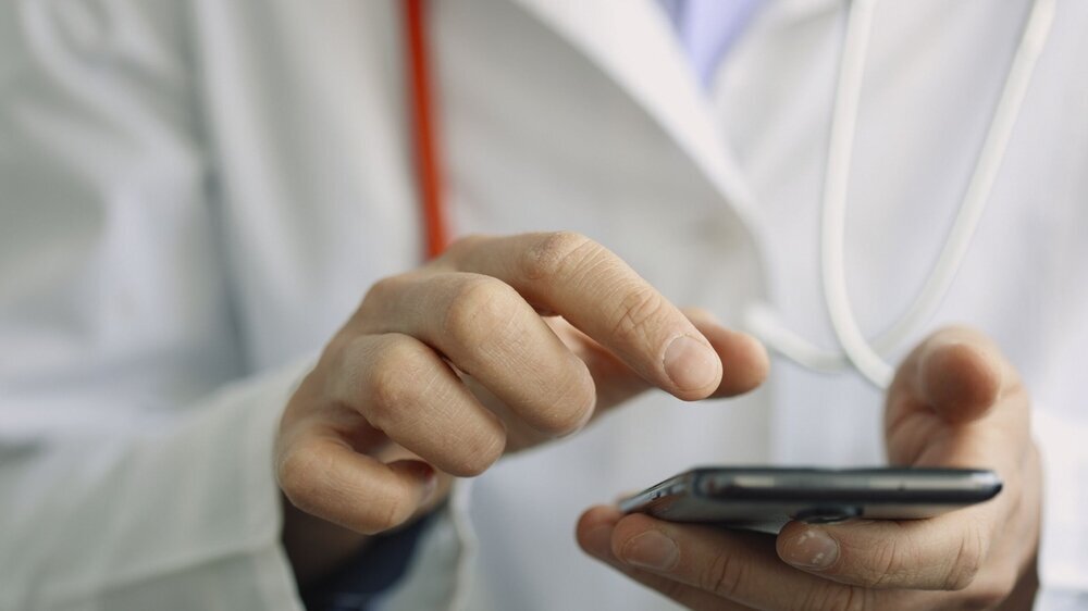 Male hands of medicalc doctor typing SMS message on smart phone. Male hands of medicalc doctor typing SMS message on smart phone. Doctor gives online medical advice and recommendations for treatment to patient or searching information
