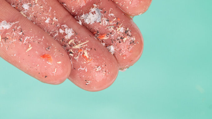 Microplastics in hand of man over water Environmental pollution and water microplastics. mikroplastik