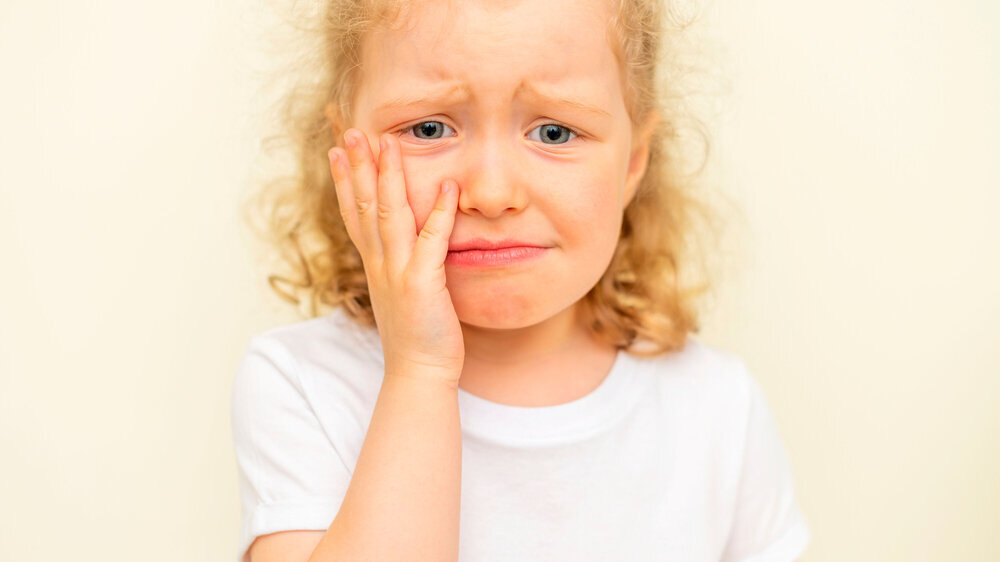 The child has a toothache. Children's caries. Kind mit Zahnschmerzen