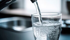 Trinkwasser fließt aus dem Wasserhahn in ein Glas.
