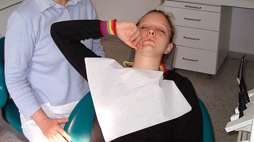 Die Zahnärztin suggeriert hypnotische Suggestionen zu einer entstehenden Kälte.