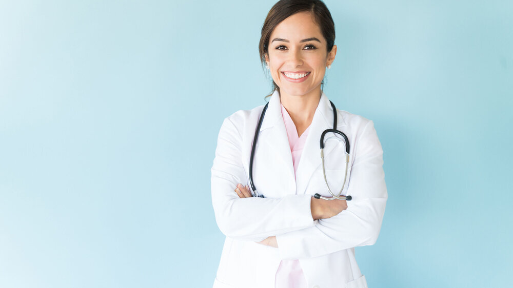 Junge Ärztin im Arztkittel und mit Stethoskop.