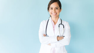 Junge Ärztin im Arztkittel und mit Stethoskop.