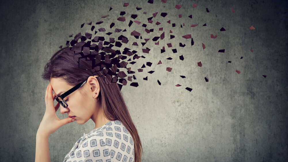 Young woman losing parts of head as symbol of decreased mind function. Memory loss due to dementia or brain damage. Young woman losing parts of head as symbol of decreased mind function.