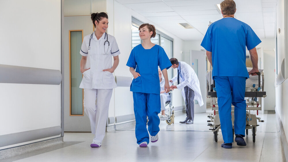 Krankenhausflur mit Personal und Krankenbett Krankenhausflur mit Personal und Krankenbett