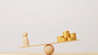 Waage zeigt Ungleichgewicht zwischen Männchen und Geldstapel.