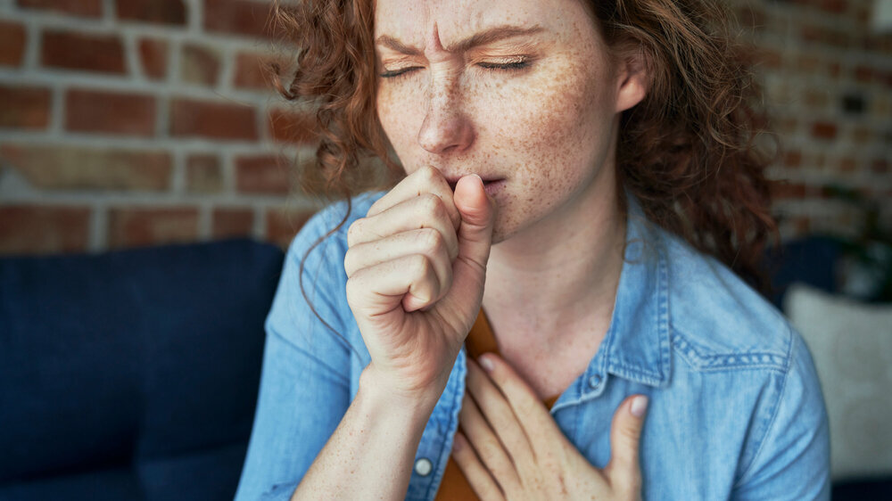Caucasian red head woman coughing and having lungs infection Frau hustet