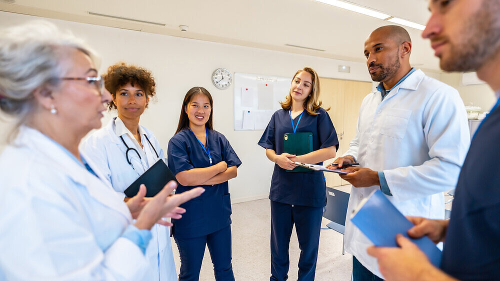 Verschiedene medizinische Fachkräfte arbeiten zusammen, tauschen Fachwissen aus und besprechen Patienteninformationen in Besprechung im Krankenhaus Verschiedene medizinische Fachkräfte arbeiten zusammen, tauschen Fachwissen aus und besprechen Patienteninformationen in Besprechung im Krankenhaus