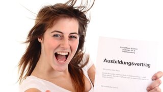 Junges Mädchen hält Ausbildungsvertrag in der Hand