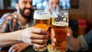 Männer prosten mit Biergläsern