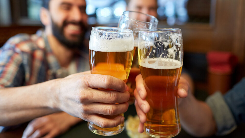 Männer prosten mit Biergläsern Männer prosten mit Biergläsern