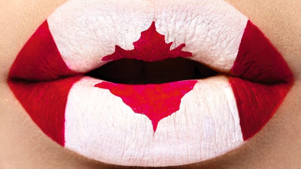 Female lips close up with a picture flag of Canada. Red, white, maple leaf Kanada Mund