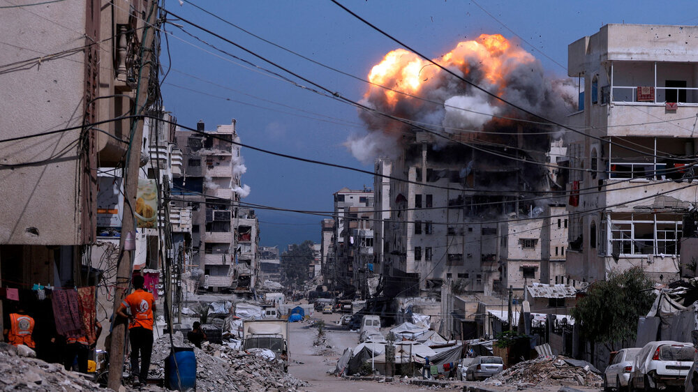 A view of destruction and rising smoke following a strike in Gaza City, capturing the impact of ongoing conflict in an urban environment.