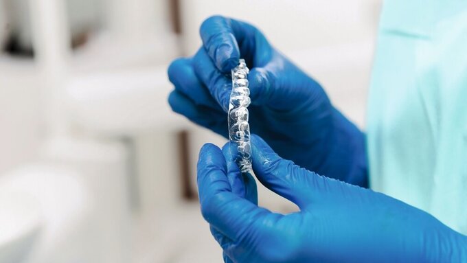 Close up photo of dentist holding invisible aligners Aligner