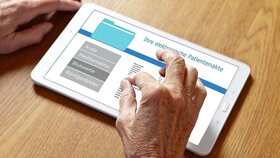 Hands of an old woman touching the screen of a tablet computer, translation of german text: your personal patient record.