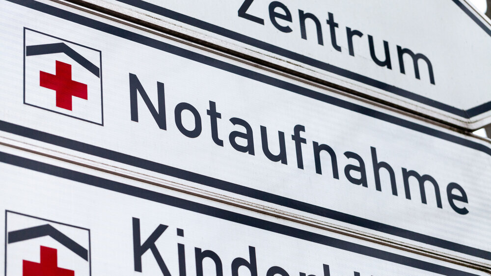 German accident and emergency department sign stands on a street. Notaufnahme is the german word for accident and emergency department. Bereits heute sei zu beobachten, dass eine große Zahl an Patientinnen und Patienten zu den regulären Öffnungszeiten der Praxen Notfallstrukturen aufsuchten, argumentieren die Hartmannbund-Verbände.