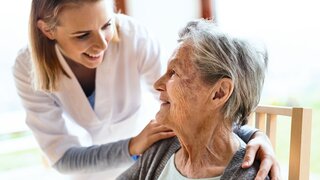 Health visitor and a senior woman during home visit.
