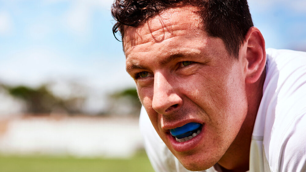 Ein junger Mann, der beim Rugby einen Mundschutz trägt. Ein junger Mann, der beim Rugby einen Mundschutz trägt.
